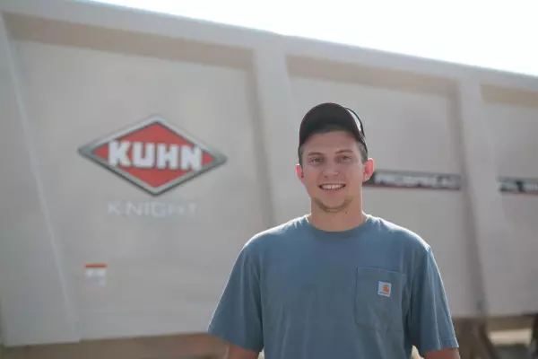 Kuhn employee in front of a KUHN Knight manure spreader